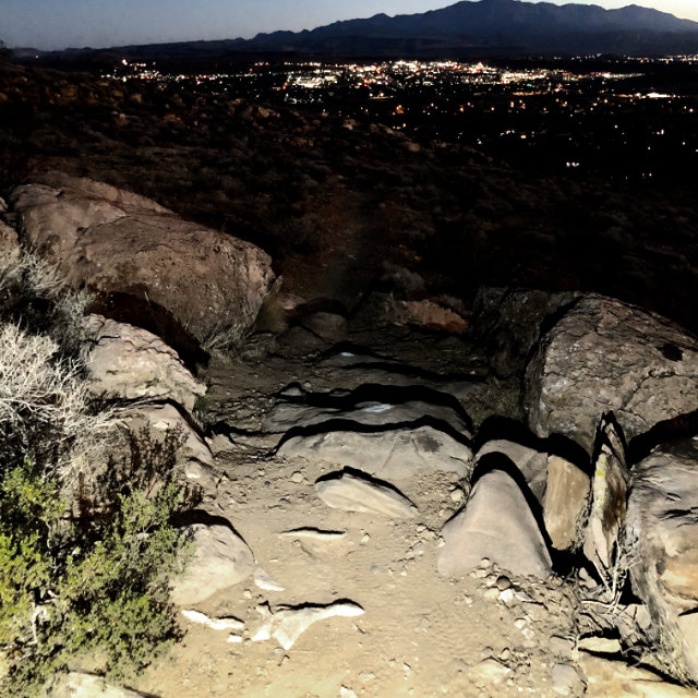 A photo of a trail lit by a waist light.